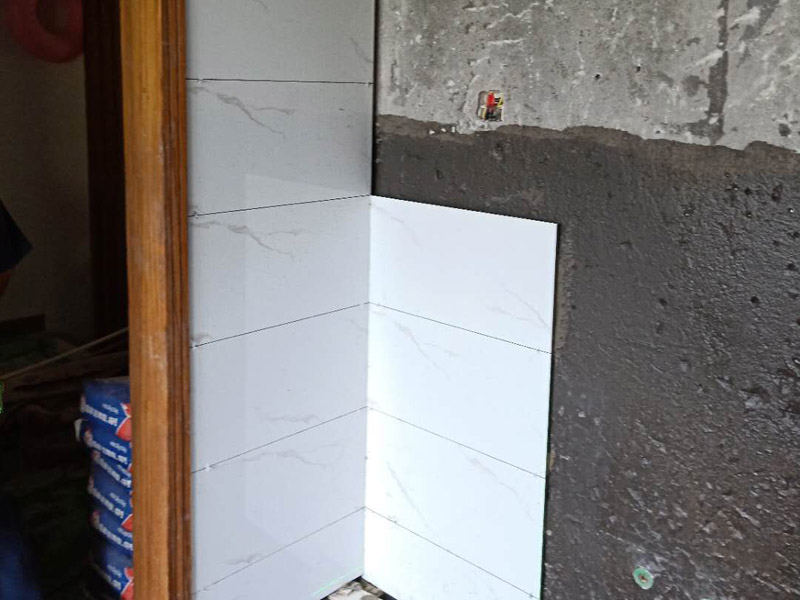 衛(wèi)生間墻面瓷磚鋪貼：首先應(yīng)除去基層表面的污垢，油漬，浮灰;除去基層上所有涂料層，膩子層;如果基層未能達到平整度要求，需對基層進行預(yù)先的找平處理；鋪貼瓷磚前需事先找好垂直線，以此為基準(zhǔn)鋪貼的瓷磚高低均勻、垂直美觀;將調(diào)制好的漿料均勻地抹在瓷磚背面，要求漿料飽滿；將瓷磚平整地鋪貼在基層上，使用橡膠錘將瓷磚拍實鋪平。