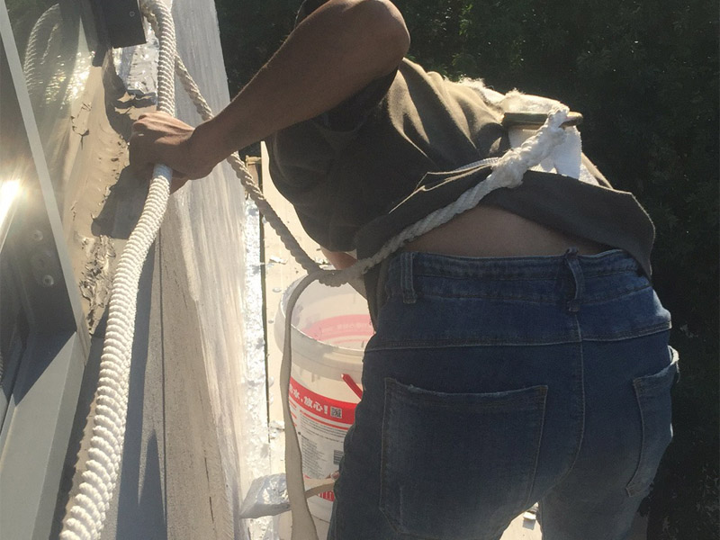 高空外墻粉刷裝修:1、基層處理：在對外墻粉刷之前，首先需要將墻面基層的灰塵與雜志清理干凈，那些比較破舊的層面與耐水性較差的涂層需要鏟除，如果表面有凹凸不平的地方，則需要用水泥砂漿進(jìn)行抹平。2、刷底膠：在對墻面刷底膠時，需要先將膠水按照說明書上注明的比例進(jìn)行稀釋，稀釋好之后，再將膠水用輥筒均勻涂刷墻面兩遍左右，注意膠水的薄厚要均勻，不能過多也不能過少。3、局部補(bǔ)膩?zhàn)樱夯鶎拥啄z干燥之后，則需用膩?zhàn)訉γ嬲移健?、滿刮膩?zhàn)樱耗佔(zhàn)臃旁谕邪逯希尯笤儆孟鹌す伟鍖γ孢M(jìn)行涂刷，最好從上往下涂，最好涂刷2到三遍，需要注意的是，膩?zhàn)硬荒芡克⑻?，膩?zhàn)油克⒑笮枰蒙凹堖M(jìn)行打磨，打磨力度需要合適，打磨完之后需要將表面灰塵給清除。5、刷底涂料：采用滾筒對墻面涂刷，涂刷時需要均勻，不能漏刷，也不能刷得過厚，底料干后，如果表面有要進(jìn)行修補(bǔ)的地方，最好用膩?zhàn)舆M(jìn)行修復(fù)在進(jìn)行砂平。