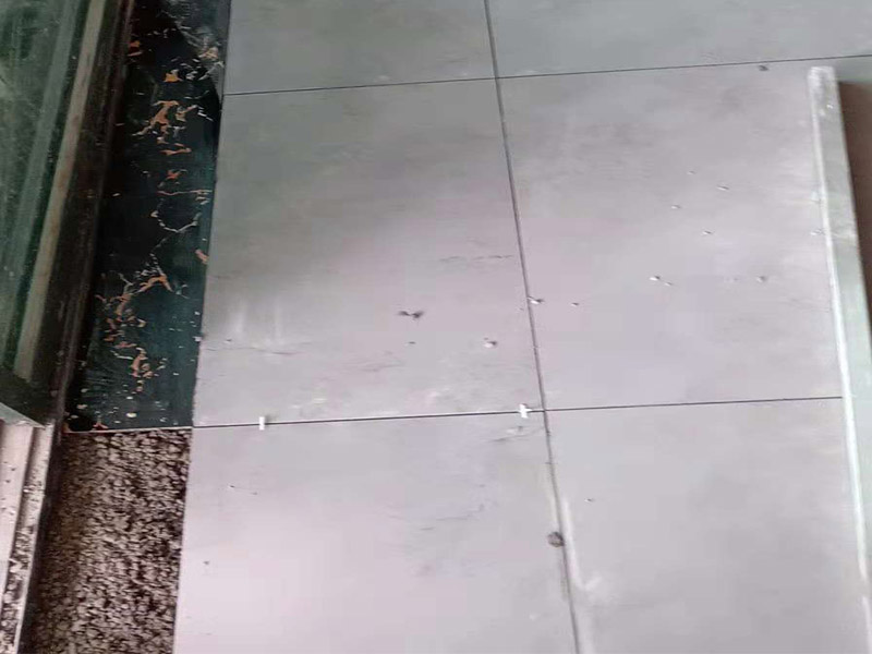 客廳地磚鋪貼：鋪貼的工具包括橡膠錘和粘結(jié)劑。在進(jìn)行施工之前先把所需要的這些材料都整理好放在一旁備用；基層的處理工作對瓷磚的平整度有很大的影響，對于基層要做好清潔工作，還有找平工作。放樣：在進(jìn)行瓷磚的鋪貼工作之前還事先找好垂直線，這樣可以在鋪貼的時候找到瓷磚的水平線，讓瓷磚鋪貼的更加的平整。粘結(jié)劑加水?dāng)嚢杈鶆?，靜置10分鐘之后就可以使用。將瓷磚表面的浮灰清除，再在瓷磚背面均勻的涂抹上粘結(jié)劑，按照預(yù)鋪的順序?qū)⒋纱u鋪貼在地面上，最后用橡膠錘輕輕拍打至服帖齊整。