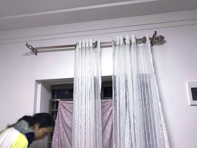 窗簾桿安裝：首先羅馬窗簾桿長度超過2.5米，需要三個(gè)安裝碼。其次中間的安裝碼為于窗戶或墻壁中心，兩端安裝碼需等距離窗戶邊緣至少5-10cm，窗簾桿需離窗戶頂端15-20cm。然后打孔深度為3.5-5cm，不能跑眼，歪斜。接著安裝碼用自攻螺絲堅(jiān)固，吊環(huán)套入桿內(nèi)，吊環(huán)一分為二，兩端各留一個(gè)吊環(huán)，將羅馬窗簾桿壓入開口安裝碼內(nèi)。之后進(jìn)行調(diào)整，使兩端裝飾頭離開墻壁距離一致。最后將窗簾穿好掛鉤，把掛鉤的另一端掛入吊環(huán)的孔內(nèi)，左右開合窗簾，檢查滑動是否靈活、兩副窗簾是否等高，否則需進(jìn)行微調(diào)。
