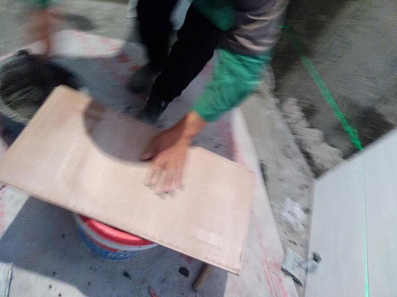 廁所墻面貼瓷磚：廁所貼瓷磚：首先應除去基層表面的污垢，油漬，浮灰;除去基層上所有涂料層，膩子層;如果基層未能達到平整度要求，需對基層進行預先的找平處理；鋪貼瓷磚前需事先找好垂直線，以此為基準鋪貼的瓷磚高低均勻、垂直美觀；應對瓷磚的色彩、紋理、表面平整等進行嚴格的挑選，然后按照圖紙要求預鋪，調(diào)制粘結劑；然后將調(diào)制好的漿料均勻地抹在瓷磚背面，要求漿料飽滿，瓷磚平整地鋪貼在基層上，使用橡膠錘將瓷磚拍實鋪平；最后瓷磚鋪貼結束后24小時，可進行嵌縫施工，嵌縫后用浸濕的織物清理多余的嵌縫劑，保持瓷磚表面清潔。