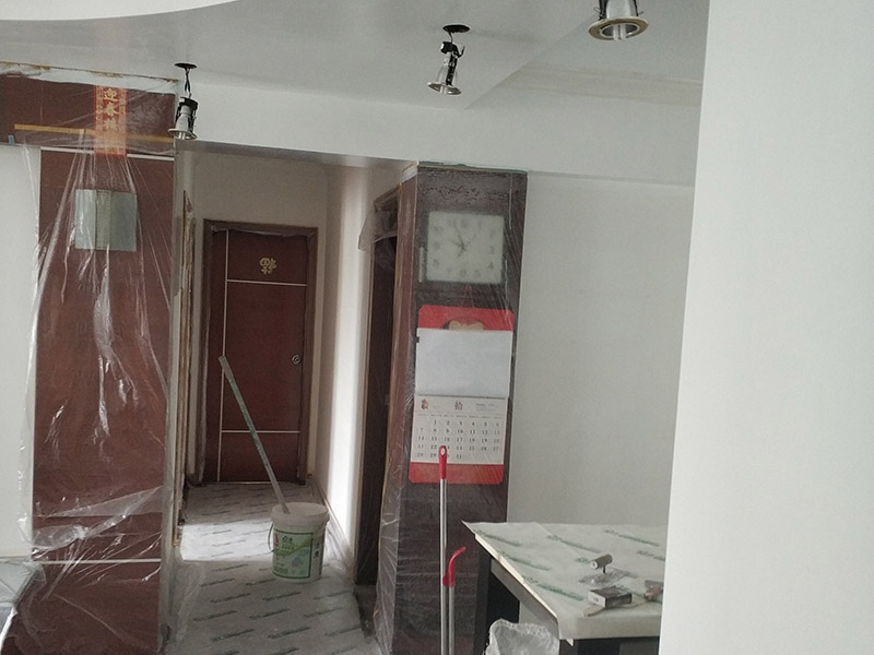 墻面翻新，地面保護(hù)：為了避免施工中磕碰到業(yè)主的家俱等物件，特地將這些物件搬到房屋中間。很快房間內(nèi)可以搬動(dòng)的物件，就都搬到了房屋的中間位置。為了避免涂料意外滴上，包上了保護(hù)膜。在鏟除舊墻面時(shí)還會(huì)留心用小托盤接住，以免弄臟業(yè)主家的地面。將踢腳線等與墻面接觸的位置及地面做好遮蔽，以免將涂料碰到木器上。 墻面應(yīng)先除掉浮灰，鏟除起砂翹皮的位置;對(duì)油污的位置，應(yīng)先將原有涂層鏟掉，不能鏟掉的要徹底清洗干凈。選用顆粒細(xì)度較大和質(zhì)地較硬的膩?zhàn)庸蝺?，底漆必須要刷勻，保證墻面每個(gè)地方都刷到，如果墻面吃漆量較多，底漆最好適當(dāng)?shù)募右稽c(diǎn)水，以保證可以涂刷均勻。這里上漆的量就是通常上的上漆工作了，不能加過量的水，會(huì)對(duì)漆膜厚度、手感和漆膜的硬度等產(chǎn)生影響。