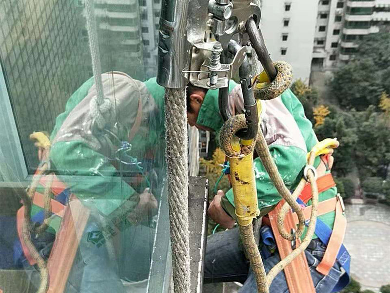 高空外墻施工：1、目前外墻粉刷主要有兩種方式：吊板方式和吊籃方式。 2、吊板方式是用吊繩、吊板將人吊到工作位置進行清洗。一般的大樓都可以用這種方式進行清洗，但是這種方式的操作必須使安全措施到位，否則危險性很大，造成傷亡事故的都是因安全措施不到位造成的。 3、墻面破損、裂縫、不平整等部位在底涂前用外墻耐水膩子修補平整。每次批刮膩子的厚度控制在2mm之內(nèi)，批刮膩子的總厚度不超過5mm。膩子應堅實牢固，不得粉化、起皮或干裂。 4、干后，要用砂紙打磨平整，再用濕布將膩子上的浮灰抹去，并盡快涂漆，以免再次落灰。