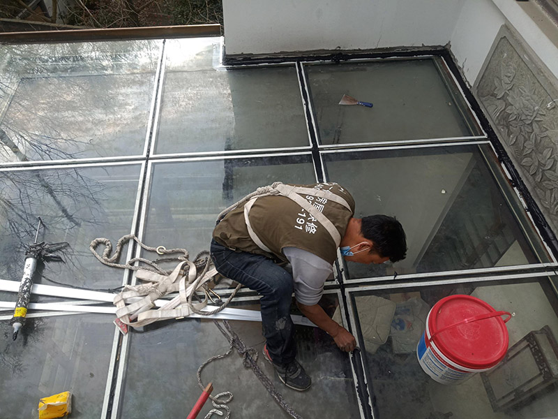 陽光房打防水膠：在陽光房施工完成后，如果陽光房與墻體有銜接的地方，一定要記住鏟去墻體上原有的涂料，否則粘合陽光房與墻體的膠水就不能很好的發(fā)揮粘合的作用，等到膠水完全凝固后會損壞墻體的涂料，造成陽光房的滲漏。最好的解決方法就是事先鏟去原墻體上涂料，在打膠之后，在陽光房與墻體接縫處上覆蓋防水擋板并且安裝一個排水槽，這樣就可以確保陽光房不漏水。