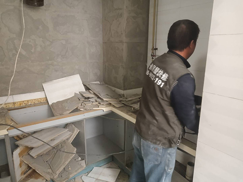 廚房瓷磚拆除：墻面上應(yīng)該還有些其他東西，比如掛毛巾的架子，放廚具的架子等等。先把這些物品都小心翼翼的拆下來(lái)，還原一面光潔的墻面，才好進(jìn)行拆卸工作。拆卸的時(shí)候要先從墻低的第一塊磚開(kāi)始拆卸，要是直接隨便從上面那一塊拆卸，拆到一半就會(huì)擋住下面的瓷磚，讓下面的瓷磚不好拆了。先用垂子敲最下面的那塊磚，把瓷磚敲松動(dòng)。送動(dòng)后，再用戴了手套的手把瓷磚拿下來(lái)，小心碎了瓷磚不要?jiǎng)澋绞至恕２鹦断聛?lái)的瓷磚堆積在地上很不方便繼續(xù)工作，這個(gè)時(shí)候上面提到的推車就派上用場(chǎng)了。用推車把瓷磚運(yùn)走，清理干凈現(xiàn)場(chǎng)，然后繼續(xù)拆卸，直到整面的墻面都拆卸完整。