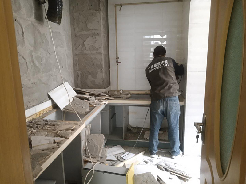 廚房瓷磚拆除：墻面上應(yīng)該還有些其他東西，比如掛毛巾的架子，放廚具的架子等等。先把這些物品都小心翼翼的拆下來(lái)，還原一面光潔的墻面，才好進(jìn)行拆卸工作。拆卸的時(shí)候要先從墻低的第一塊磚開(kāi)始拆卸，要是直接隨便從上面那一塊拆卸，拆到一半就會(huì)擋住下面的瓷磚，讓下面的瓷磚不好拆了。先用垂子敲最下面的那塊磚，把瓷磚敲松動(dòng)。送動(dòng)后，再用戴了手套的手把瓷磚拿下來(lái)，小心碎了瓷磚不要?jiǎng)澋绞至恕２鹦断聛?lái)的瓷磚堆積在地上很不方便繼續(xù)工作，這個(gè)時(shí)候上面提到的推車就派上用場(chǎng)了。用推車把瓷磚運(yùn)走，清理干凈現(xiàn)場(chǎng)，然后繼續(xù)拆卸，直到整面的墻面都拆卸完整。