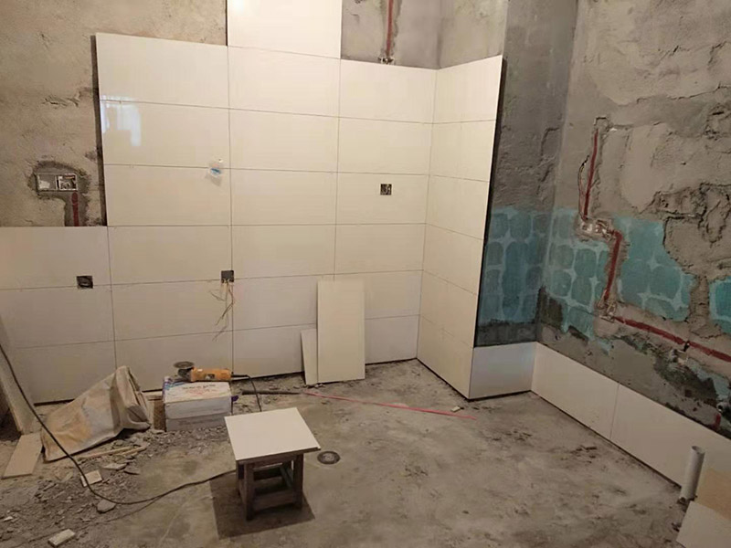 浴室墻面貼瓷磚：貼瓷磚之前先要用水浸泡瓷磚2小時(shí)左右。泡水的目的是為了讓瓷磚能事先吸飽水分，避免鋪貼之后吸走粘接材料中的水分，從而影響粘接的強(qiáng)度，浸水后記得用棉布擦去表面的水分晾干后才能進(jìn)行鋪貼。鋪貼開始前還應(yīng)吊垂線，來確定瓷磚的尺寸線，然后開始貼瓷磚，一般都是從門窗先開始，而且按由下而上，自左至右的順序進(jìn)行。鋪貼的方法是先用水潤濕找平層，然后用鏟子將事先拌好的粘接材料抹在瓷磚背面，再將瓷磚貼在墻上即可，依次鋪貼平整就可以了。