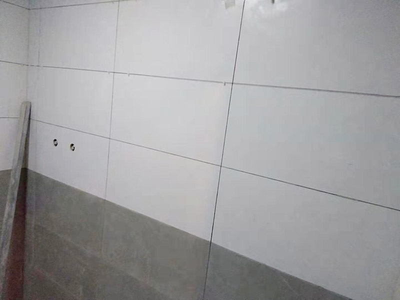 浴室墻面貼瓷磚：貼瓷磚之前先要用水浸泡瓷磚2小時(shí)左右。泡水的目的是為了讓瓷磚能事先吸飽水分，避免鋪貼之后吸走粘接材料中的水分，從而影響粘接的強(qiáng)度，浸水后記得用棉布擦去表面的水分晾干后才能進(jìn)行鋪貼。鋪貼開始前還應(yīng)吊垂線，來確定瓷磚的尺寸線，然后開始貼瓷磚，一般都是從門窗先開始，而且按由下而上，自左至右的順序進(jìn)行。鋪貼的方法是先用水潤濕找平層，然后用鏟子將事先拌好的粘接材料抹在瓷磚背面，再將瓷磚貼在墻上即可，依次鋪貼平整就可以了。