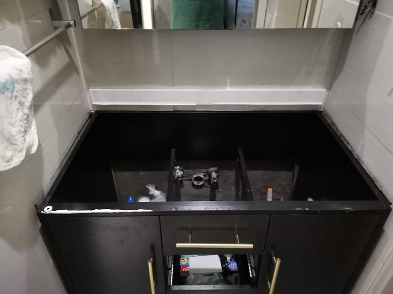 浴室柜安裝：在標(biāo)注好的位置，用氣鉆打孔先安裝主柜；再安裝洗臉盆，用玻璃膠固定好；再安裝水龍頭，接著就是下水器；安裝鏡子，還有置物架；完成。