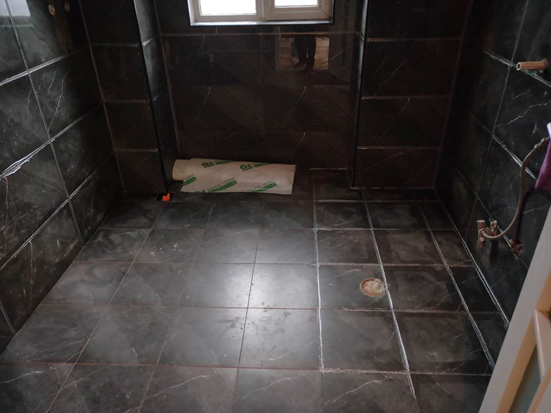 衛(wèi)生間美縫施工：使用用開槽器/平口螺絲刀/勾縫刀，清理瓷磚縫隙內(nèi)灰塵及垃圾，這一步需要力度適中，不要用蠻力，不然可能存在崩壞瓷磚的風(fēng)險。然后用吸塵器，掃把或者抹布清理干凈。，建議縫隙在1.5到2mm深度合適。縫隙清理干凈后， 擰開管蓋裝上混合管，管頭卡在膠槍的卡口上。裝好混合管后，從下方用美工刀斜切45度角，切記開口要比瓷磚縫隙小，如果本身瓷磚縫隙比較小，可以不用切膠嘴。首先打出30-40CM美縫劑余料，然后沿著瓷磚縫隙開始施工，在施工的時候一定要美縫劑填充滿瓷磚縫隙，不然后續(xù)可能會發(fā)生塌陷。瓷磚縫隙打膠方法先豎后橫，沿著縫隙均勻打出美縫劑.一般有些師傅打出3-5米時停下，開始用壓邊球壓縫，十字交叉口處多壓幾次，這樣會很美觀。壓縫的工具比較多，可用刮板或者壓縫 鋼球、手指套沿著縫隙壓出 U型面就可以了