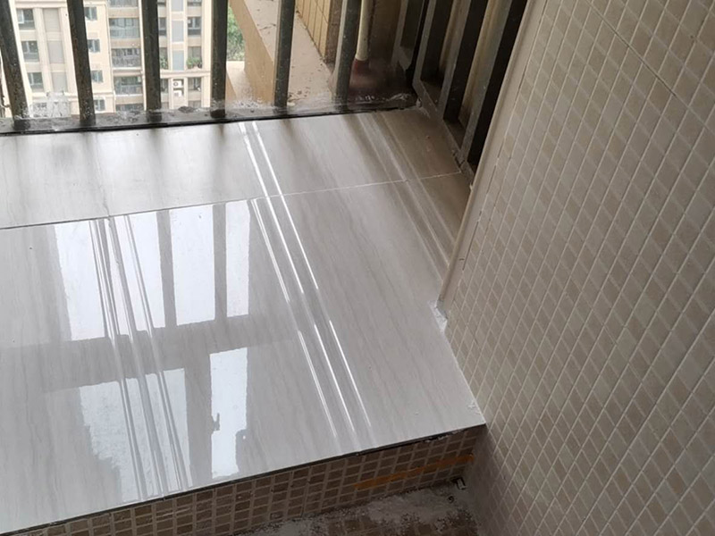 陽臺瓷磚鋪貼：準(zhǔn)備粘結(jié)劑前，瓷磚不應(yīng)浸水，但要用鋼絲刷除去磚背面的松散物質(zhì)，并用濕布抹去磚背的浮塵。然后按照生產(chǎn)商建議的比例將水或乳液放到攪拌桶中攪拌直至粘結(jié)劑均勻無結(jié)塊。初始攪拌后的粘結(jié)劑應(yīng)靜置在攪拌桶中，直到生產(chǎn)商推薦的熟化時間過后攪拌一下再使用。 在鋪壓瓷磚前，在瓷磚背面也批一薄層粘結(jié)劑。這種雙批法雖然用的材料和工時比較多，但卻能夠保證粘貼的質(zhì)量和耐久性。 在粘結(jié)劑量置晾時間內(nèi)，將準(zhǔn)備好的瓷磚鋪壓到位，垂直于梳理方向輕微搓動以排出磚下的空氣。鋪貼到位后用橡皮錘輕擊，用尺寸合適的十字定位架來調(diào)整表面平整度及接縫的平直。