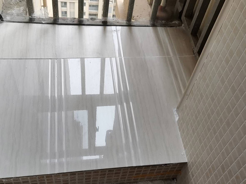 陽臺瓷磚鋪貼：準(zhǔn)備粘結(jié)劑前，瓷磚不應(yīng)浸水，但要用鋼絲刷除去磚背面的松散物質(zhì)，并用濕布抹去磚背的浮塵。然后按照生產(chǎn)商建議的比例將水或乳液放到攪拌桶中攪拌直至粘結(jié)劑均勻無結(jié)塊。初始攪拌后的粘結(jié)劑應(yīng)靜置在攪拌桶中，直到生產(chǎn)商推薦的熟化時間過后攪拌一下再使用。 在鋪壓瓷磚前，在瓷磚背面也批一薄層粘結(jié)劑。這種雙批法雖然用的材料和工時比較多，但卻能夠保證粘貼的質(zhì)量和耐久性。 在粘結(jié)劑量置晾時間內(nèi)，將準(zhǔn)備好的瓷磚鋪壓到位，垂直于梳理方向輕微搓動以排出磚下的空氣。鋪貼到位后用橡皮錘輕擊，用尺寸合適的十字定位架來調(diào)整表面平整度及接縫的平直。