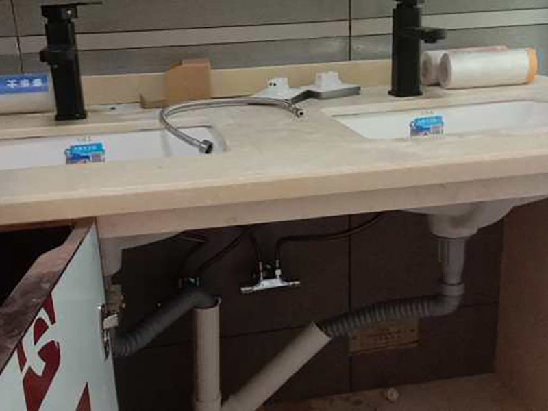 臺盆五金安裝：1.檢查預(yù)留給排水管路，安裝支撐洗面盆臺面的鋼制支架。 2.根據(jù)臺下盆包裝箱內(nèi)的臺面切割圖將臺面開孔打磨完畢。 3.按照安裝的龍頭和臺面尺寸正確切割龍頭安裝孔，打磨。 4.把洗面盆暫時放入已開好的臺面安裝口內(nèi)，檢查間隙，并做好記號。 5.檢查校驗后，把洗面盆放平，在洗臉盆邊緣上口涂上硅膠密封材料后，把洗面盆小心放入臺面下，對準(zhǔn)安裝孔，跟先前的記號相校準(zhǔn)并向上壓緊，并使用廠家隨貨附帶的臉盆與臺面的連接件，將洗臉盆與臺面緊密連接。 6.臺下盆邊緣打膠。 7.安裝臺下盆上下五金件。 8.等密封膠硬化后，連接進(jìn)水和排水管件。