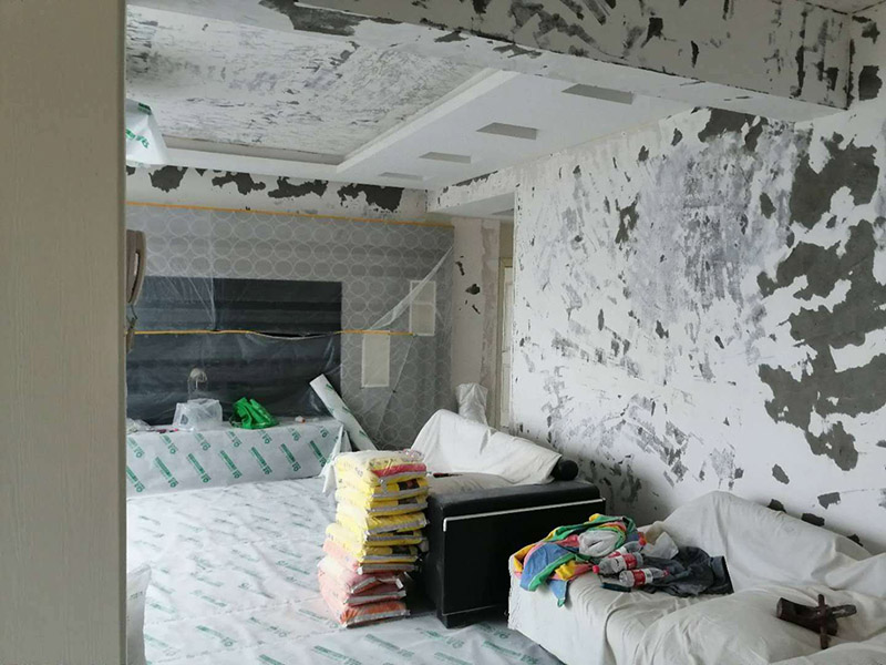 墻面基層刷防固漆：首先我們要把墻體上的工業(yè)大白鏟掉，這種工業(yè)大白是開發(fā)商為了交房刷的一層膩?zhàn)臃?，它?huì)遮蓋空鼓裂縫，所以我們需要鏟掉，然后做基層處理，主要是處理空鼓和裂縫，空鼓用錘子敲開然后用水泥砂漿填平，裂縫就用嵌縫帶嵌上。接著刷一層界面劑，這個(gè)界面劑就是黃墻綠地的效果，可以稱為墻固地固，一般毛坯墻中都會(huì)含有工業(yè)氨水，而它會(huì)持續(xù)不斷的釋放一種有害氣體--氡氣，這個(gè)氡氣對(duì)我們的呼吸道和關(guān)節(jié)有一定的危害，所以界面劑一個(gè)作用就是為了防止墻體中的氡氣進(jìn)入室內(nèi)。也可以增加墻面和膩?zhàn)拥母街Γ鰪?qiáng)刷漆質(zhì)量。地固的話可以防止工地灰塵煙塵太大，會(huì)影響工人施工，另外也可以防止灰塵附著在某些家具表面，影響后期家具漆的效果。