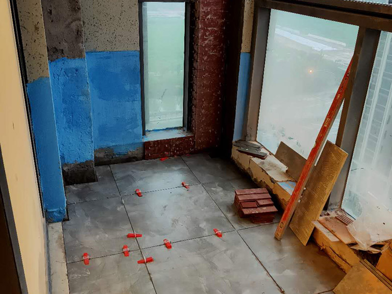 陽(yáng)臺(tái)防水貼磚:在粘結(jié)劑量置晾時(shí)間內(nèi)，將準(zhǔn)備好的瓷磚鋪壓到位，垂直于梳理方向輕微搓動(dòng)以排出磚下的空氣。鋪貼到位后用橡皮錘輕擊，用尺寸合適的十字定位架來(lái)調(diào)整表面平整度及接縫的平直。鋪設(shè)好的磚面應(yīng)該及時(shí)清理干凈，特別是去除殘留其上的粘結(jié)劑。合格的粘結(jié)劑干硬后即使在陶瓷磚面上也不易被清除掉。清理好的瓷磚面應(yīng)該立即擺放標(biāo)識(shí)進(jìn)行隔離，避免污染或擾動(dòng)，直到下一個(gè)填縫工序。