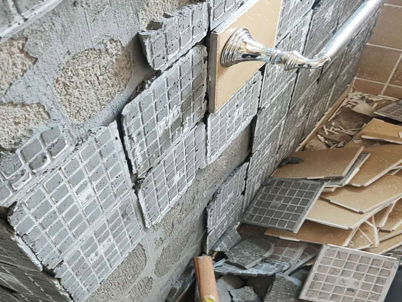 瓷磚空鼓脫落鋪貼:將挑選好的瓷磚浸泡在水盆里，浸泡時(shí)間按瓷磚的密度而定，以水盆里不出水泡為好，說明瓷磚內(nèi)部已無空氣。瓷磚泡好后，將瓷磚從水盆里拿出來，瀝瀝水，瓷磚有水較滑，動(dòng)作要輕巧小心，以免瓷磚滑落摔破。晾干后，瓷磚鋪貼平整，也要求墻壁本身要平整，用直尺在毛坯房墻面找平。將801膠水與水按1：5的比例調(diào)配，膠水取代傳統(tǒng)的黃沙讓泥漿更有粘性。墻面如果有不平整的地方，用鏟刀修理平整，再用直尺檢測(cè)全部平整才合格。在墻壁上涂一層防水涂料，以防止衛(wèi)浴間的水汽滲進(jìn)墻壁。這個(gè)步驟很重要，一定不可省略。