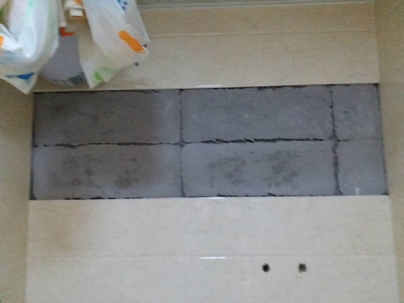 墻面瓷磚脫落修補(bǔ)：首先將脫落的磚四周用裁紙刀的刀背咔嚓一遍，將勾縫劑或水泥等附著物清理掉，漏出瓷磚的原邊。同時(shí)需要清理的，還有墻上與脫落瓷磚相連的瓷磚邊緣。當(dāng)然，用刀刃也可以，但比較毀刀片。然后用稍微潮濕的抹布擦干凈瓷磚背面的浮灰，最好用鋼絲球來(lái)刷一遍瓷磚背面再擦，目的是去掉可能存在的脫模劑。接著就是清理墻面的水泥砂漿層，將松動(dòng)的碎塊去掉，然后也整體用抹布擦一遍。將玻璃膠用裁紙刀切掉密封出口，如果有槍嘴就擰上槍嘴，沒有也可以直接用。如果墻上的水泥砂漿四周有縫隙，可在縫隙內(nèi)也擠些玻璃膠，這樣可以連接那些沒掉的瓷磚，防止附近的瓷磚將來(lái)也脫落。然后將這背面抹膠的瓷磚貼回原處，磚與磚之間插上牙簽來(lái)留縫隙。再用手指抹玻璃膠到磚與磚之間的縫隙里。