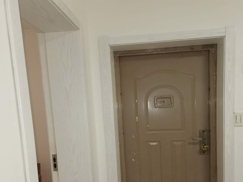 門套更換安裝案例：師傅將木工板裁成等寬大小的尺寸，再做成了這樣的一個(gè)門框，這是門套的基本框架，材料一定要選用上好的木工板，門本身的重量，門在日常使用中會(huì)有一定的力度，都由門套來(lái)承載，一般都會(huì)用柳安等結(jié)實(shí)的木頭做芯材的木工板，這些木材的硬度較高，螺絲不容易松動(dòng)，這樣門不容易下垂。用電錘在墻上打眼，釘上適當(dāng)大小的木鍥，劃上記號(hào)，圓釘穿過(guò)門框釘進(jìn)木鍥里，這樣就將門框固定在墻上了。貼面板時(shí)，量好尺寸大小，用美工刀在整張面板上裁下所需要的面板。如果是清水油漆，那么必須注意的是，同一扇門所使用的面板的色差一定要接近!