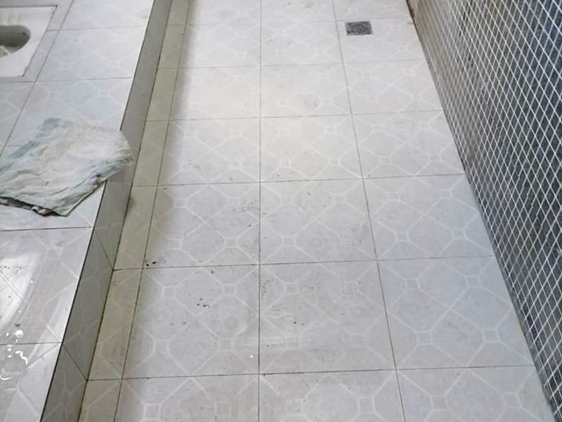 公共衛(wèi)生間貼磚施工：清理墻面上的各類污物，打掃干凈現(xiàn)場，特別是腳落里。用泥刀先批墻，后用水泥漿找平。這個工序很重要，確保底子平，防止貼后空鼓。墻面要刷防水涂料，防止貼后浸水，一般高度不低于1.8米，刷的時候會稍高一些。瓷磚上墻將經(jīng)過預(yù)先清潔的瓷磚平整地鋪貼在粘結(jié)劑漿料基層上，使用橡膠錘將瓷磚拍實(shí)鋪平。施工過程中，可小幅度轉(zhuǎn)動瓷磚，使?jié){料與瓷磚背面充分接觸。留縫大小調(diào)整根據(jù)瓷磚的尺寸，在磚與磚之間預(yù)留相應(yīng)尺寸的縫隙留待嵌縫?？捎醚篮灥认裙潭?，粘結(jié)劑具有一定的可調(diào)整性，可對留縫的大小進(jìn)行調(diào)整。