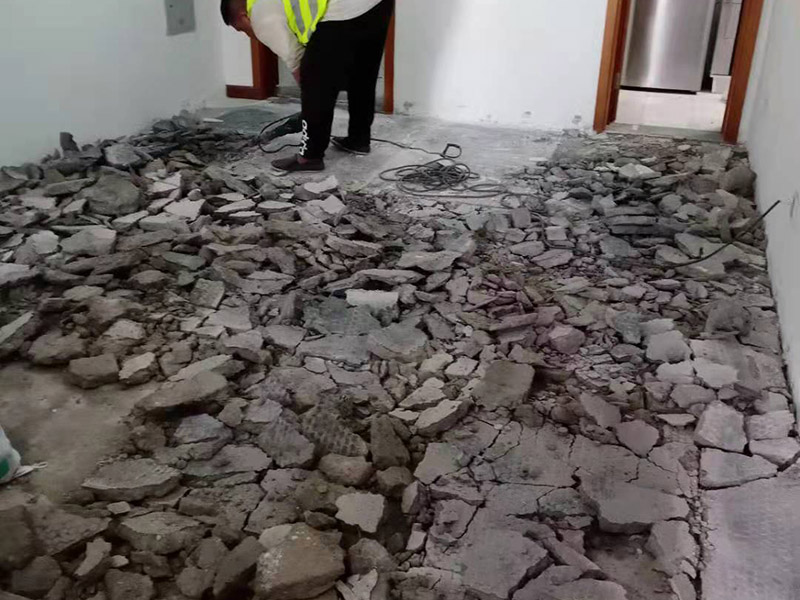 客廳地磚拆除施工：為了更好的拆除地磚，我們可以優(yōu)先從大門口那塊開始，因?yàn)榭梢愿斓恼业浇涌p，比較容易撬開。找到接縫，用扁口鑿?fù)锴恕Ｈ绾嗡嗌皾{還不是特別牢固的話，用錘子將扁口鑿輕敲進(jìn)縫隙內(nèi)，就可以瞬間將整塊地磚撬起拆除。