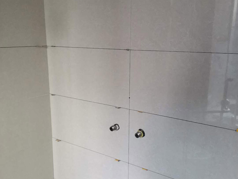 瓷磚空鼓維修鋪貼：首先，先使用空鼓錘敲擊墻面確認(rèn)空鼓范圍。如果敲擊的聲音比較沉悶的話，說明鋪貼比較實(shí)也比較牢固。反之，發(fā)出&ldquo;咚咚&rdquo;清脆的聲響的話，說明瓷磚存在空鼓。然后在開孔處注射瓷磚空鼓修復(fù)膠。如有溢出的膠水盡量在干固之前用濕抹布擦掉，如填縫處有膠水滲出是因?yàn)樵械奶羁p劑密度不夠，可重新涂抹一層密度較大的填縫劑。最后使用填縫劑填補(bǔ)孔位，擦掉多余的填縫劑。