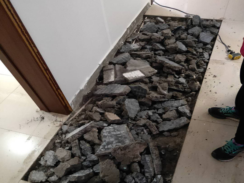 全屋瓷磚拆除施工:首先要撬開大門口的那塊地磚，因?yàn)槟菈K地du磚是有一邊露在外面的所以比較容易撬開。再用扁的鑿子一片一片的往里撬，如果水泥砂漿做的不是特別牢固的話可以直接用錘子把扁撬敲擊地磚和水泥地中間的縫隙。