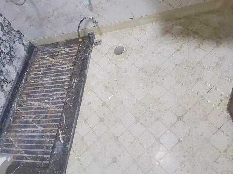 衛(wèi)生間地面防水裝修:首先要將墻面地面都要清潔干凈，這點非常重要，不能有散沙、土、石塊等干擾基層。如果基層開發(fā)商做的很不好的話，表面還要刷一層界面劑以防止墻面表面起沙。用噴壺將陰角部分和管根部分噴水，噴水的主要目的就是防止墻面吸收了堵漏寶太多的水分，造成堵漏寶沒有和墻面凝結在一起。那么噴多少水呢，建議以表面沒有明顯積水為宜。刷完以后，由于速凝型的堵漏寶干燥較快，所以基本不用等待，干的非常快。然后將第一遍堵漏寶上鋪好網(wǎng)格布，主要是防止堵漏寶初凝以后裂開。然后進行第二遍涂刷堵漏寶，刷完咱們就要進行下面柔韌性防水涂刷的步驟了。