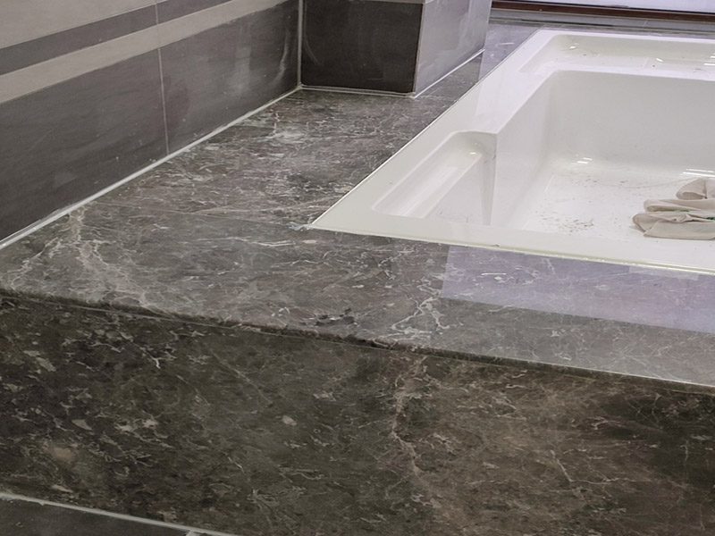 浴缸貼磚安裝：在安放浴缸時注意下水口的另一端要略高于下水口的一端，以便將來排污不暢。這一點要因情況而定。一般正常的浴缸底部本來就留出了排水的坡度。在安放浴缸時注意下水口的另一端要略高于下水口的一端，以便將來排污不暢。這一點要因情況而定。一般正常的浴缸底部本來就留出了排水的坡度。浴缸裙的貼磚是不需要抓毛的，砌好紅磚的臺子，在表面抹一層水泥砂漿，然后等兩天再來貼磚即可，貼磚很麻煩，由于地面留了坡度，而浴缸是平的，所以每一塊大磚都要打磨成不同的尺寸，不可以一次打磨很多，容易磨多了，要反復(fù)磨。磚的上邊要塞入浴缸的圓邊下，這樣才不會形成陽角。