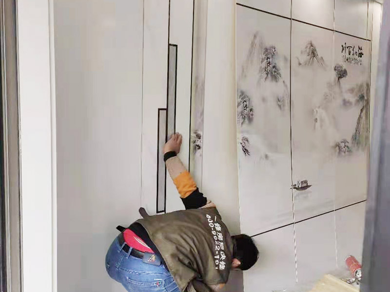 客廳背景墻安裝：在安裝護(hù)墻板前，首先對(duì)背景墻除塵和找平處理，以保證基層光滑平整且無顆粒等臟物。以確保墻板安裝時(shí)的平穩(wěn)度和牢固度。開始根據(jù)電視背景墻的尺寸切割墻板，若護(hù)墻板需做整面墻，切割時(shí)一定要注意長寬尺寸的精確度，切記偏差不可過大。開始安裝，順序是由下至上，由左至右，并距離板塊上端1.5CM左右，用膨脹螺絲將其固定住，同時(shí)注意不要露出護(hù)墻板表面，否則影響美觀度。將墻板全部安裝好后，直接使用專用膠來固定便可。 在安裝過程中要注意墻板紋飾顏色是否一致，保持分隔線一致、順暢，不可錯(cuò)亂，否則會(huì)拉低整個(gè)電視背景墻的美觀度。安裝好后對(duì)拉縫處安裝壓條，增強(qiáng)裝飾效果。