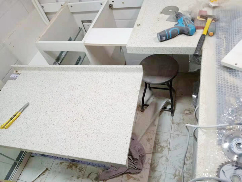 櫥柜維修改造：對廚房作防護(hù)措施,掛擋布、廚房墻面等做簡單清理,以便準(zhǔn)確測量地面水平。 材料進(jìn)場:櫥柜板材等進(jìn)場。  安裝地柜 組裝:統(tǒng)一組裝好地柜,搬進(jìn)廚房,按圖紙順序擺放好位置(倒放),統(tǒng)一安裝地腳。 現(xiàn)場切割:地面上墊上保護(hù)物,割口根據(jù)實物的大小從反面進(jìn)行操作,保持正面不崩。 安裝順序：如有轉(zhuǎn)角柜應(yīng)先安轉(zhuǎn)角柜，沒有轉(zhuǎn)角柜先從靠墻的柜往外安裝。 水平調(diào)整：通過地柜的調(diào)節(jié)腿調(diào)節(jié)地柜水平度，誤差保持正負(fù)1mm。