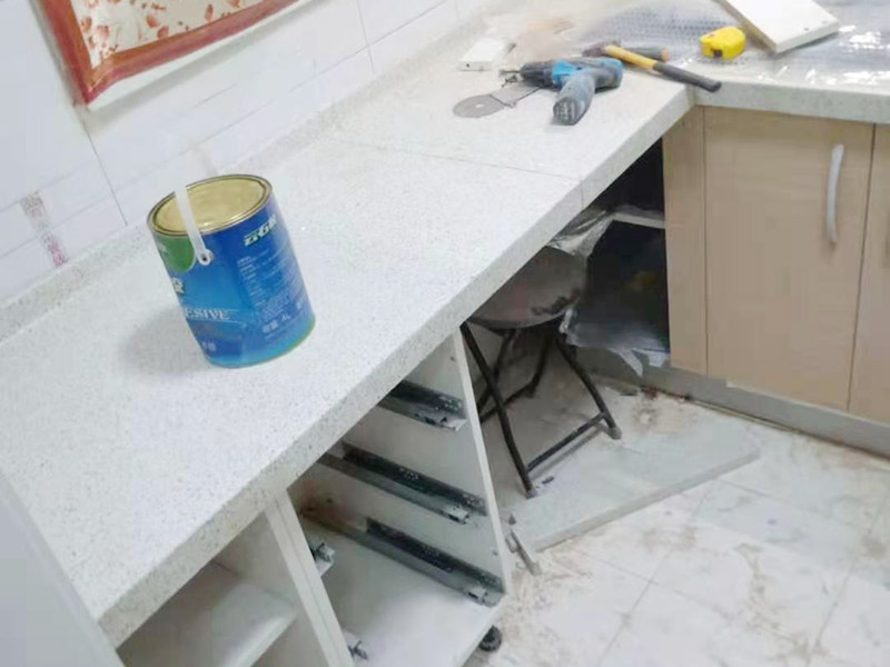 櫥柜維修改造：對廚房作防護(hù)措施,掛擋布、廚房墻面等做簡單清理,以便準(zhǔn)確測量地面水平。 材料進(jìn)場:櫥柜板材等進(jìn)場。  安裝地柜 組裝:統(tǒng)一組裝好地柜,搬進(jìn)廚房,按圖紙順序擺放好位置(倒放),統(tǒng)一安裝地腳。 現(xiàn)場切割:地面上墊上保護(hù)物,割口根據(jù)實物的大小從反面進(jìn)行操作,保持正面不崩。 安裝順序：如有轉(zhuǎn)角柜應(yīng)先安轉(zhuǎn)角柜，沒有轉(zhuǎn)角柜先從靠墻的柜往外安裝。 水平調(diào)整：通過地柜的調(diào)節(jié)腿調(diào)節(jié)地柜水平度，誤差保持正負(fù)1mm。