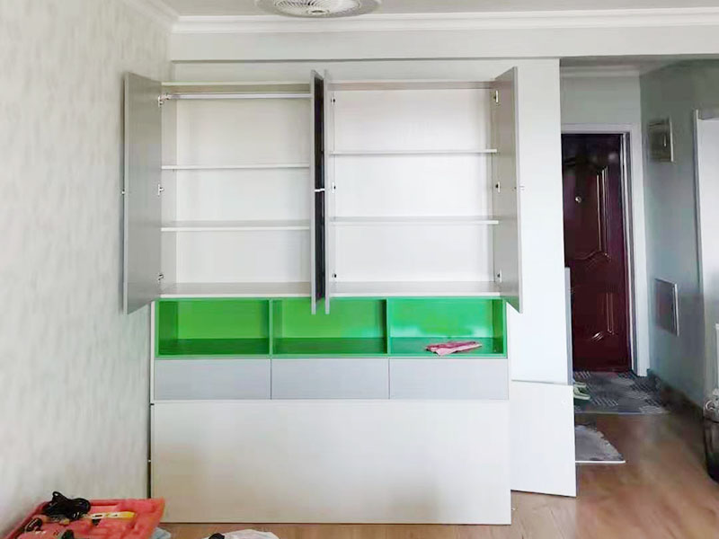 衣柜組裝施工：第一步要把柜體安裝好?？梢韵劝压褡幼髠?cè)的木板放在地上，在有膠的孔上面打上螺桿，然后把背拉條和螺桿固定在一起，要鎖上鎖柄。接著需要把頂板安裝上去，這樣一看是不是衣柜大概有了簡單的樣子呢?接下來就要安裝底板了，在底板上安裝上螺桿，固定好角條了以后，就把之前已經(jīng)組裝好的頂板和底板組裝到一起，要是中間有不會(huì)的就要參考實(shí)木衣柜安裝步驟圖，用處還是很大的，那么實(shí)木衣柜的外邊基本上就差不多了。 下面就要組裝褲架和抽屜了。在開始的時(shí)候可以先把實(shí)木衣柜的褲架和抽屜拿出來放在一邊，先將抽屜側(cè)面安上螺桿，把安裝