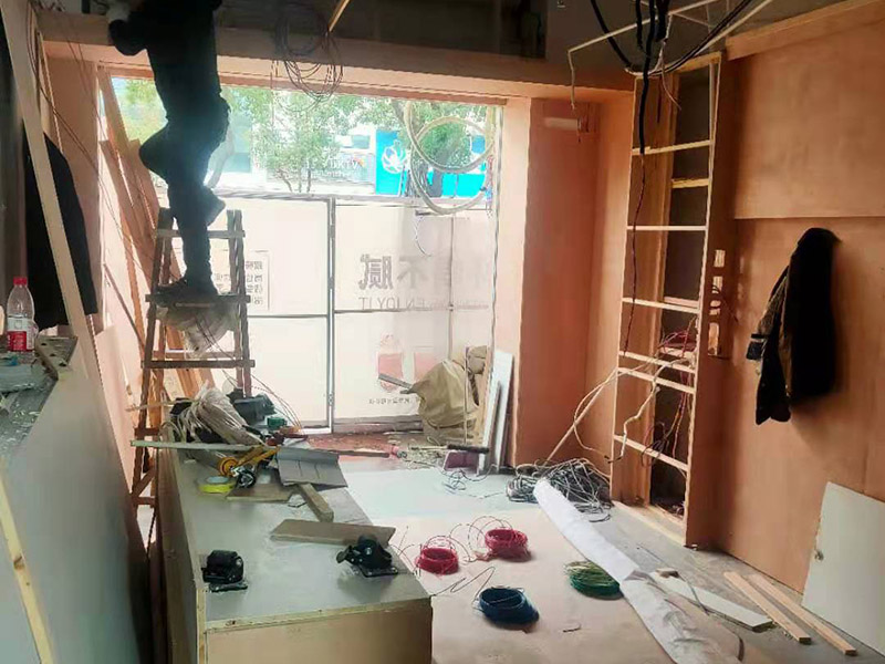 門店木工施工現(xiàn)場:首先應(yīng)該搭建木作施工臺。木作施工臺用于板材的切割板，板材的造型，板材的平整度處理等等。門窗的制作包括門窗套制作、門窗制作。要特別注意門窗扇與框之間的縫隙不能太大，以及門窗套與門窗的色差等。木作表層封裝木制品制作完成后，對其表面進行細節(jié)封裝。木作表層封裝通常就要用到各種各樣的家裝板材，特別注意板材的選購。