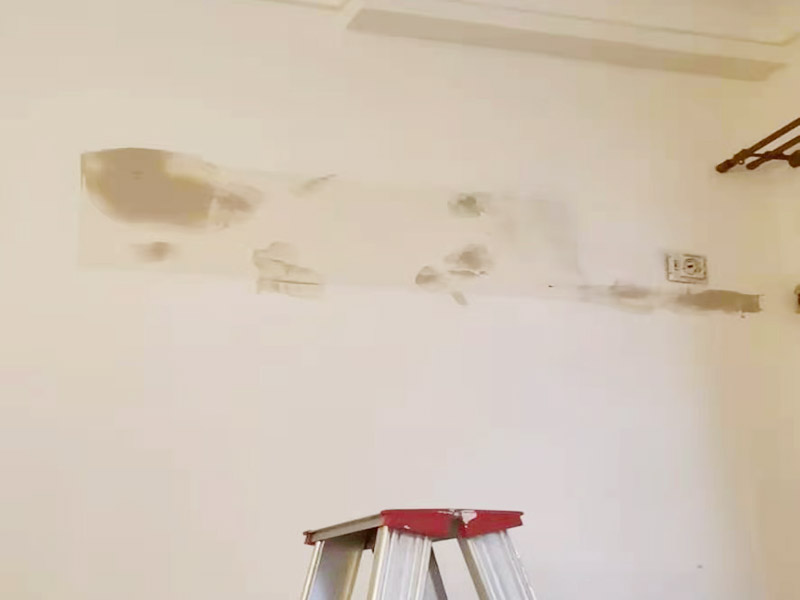 墻面刷新烤燈處理：施工前用塑料保護膜將室內(nèi)的地板覆蓋、家居包裹、電源插座覆蓋；并用膠帶貼牢。對基層原有涂層應(yīng)視不同情況區(qū)別對待：疏松、起殼、脆裂的舊涂層應(yīng)將其鏟除;粘附牢固的舊涂層用砂紙打毛;不耐水的涂層應(yīng)全部鏟除。清除基層表面塵土和其它粘附物。較大的凹陷應(yīng)用聚合物水泥砂漿抹平。并待其干燥。較小的孔洞、裂縫用水泥乳膠膩子修補。 墻面泛堿起霜時用硫酸鋅溶液或稀鹽酸溶液刷洗，油污用洗滌劑清洗，最后再用清水洗凈。