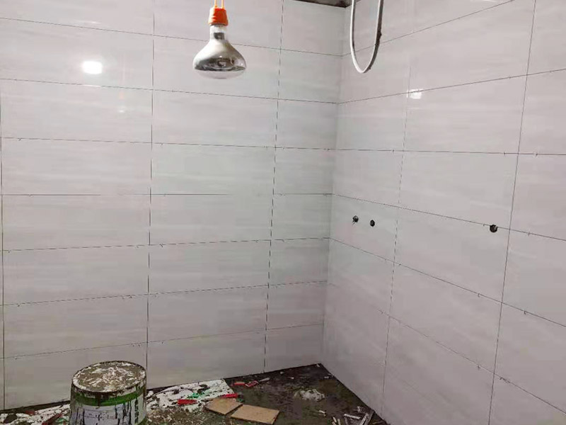 浴室貼磚裝修:把還沒有涂抹水泥的地磚鋪在地上，把它們敲平，然后在地磚上涂滿水泥，鋪在地面，保持四塊磚的對角位置對齊。 鋪瓷磚的順序其實也是有不少講究的，鋪地磚的時候應該從內向外貼，遇到坡度或者有地漏的地方，還要注意排水方向找坡；墻面磚的鋪貼應該從下向上進行。為了最后的鋪貼效果美觀，最底層的瓷磚要最后貼；墻面磚鋪貼結束以后還要壓地磚。 這里要注意的是，貼瓷磚的時候不能一面墻貼到頂，否則由于瓷磚較重容易引起脫落。鋪好了地磚盡量不要去踩。 因為瓷磚本身有許多小孔，吸水能力強，干燥的瓷磚會吸干水泥的水分.