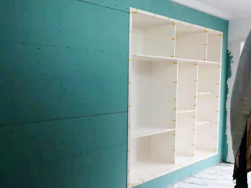 客廳定制柜體安裝：用墊布點(diǎn)好地板，先從靠墻的一端寬側(cè)板開始組裝，將寬側(cè)板平放于地面上（離后墻面保持700mm間隔）。首先將填好的三合一膠塞的板件，平放在墊布上，檢查孔距與圖紙相符，并裝上三合一單連桿。然后將固層釘上木塞，固定于寬側(cè)板上面，頂板大柄孔朝上，其余固層都朝下，腳線大柄孔朝內(nèi)（中間固層與L架高度一致，即底板到固層內(nèi)空為960mm，現(xiàn)場打?qū)影蹇祝?。放上?cè)板，釘上木塞，木塞要求連通兩邊的固層。在第二個柜固層上面裝好雙連桿，留意雙連桿上面大柄只能鎖住一半，即90&deg;。當(dāng)兩件固層與側(cè)板固定后再同時擰緊大柄。裝第三個柜時重復(fù)第二個柜的安裝步驟。