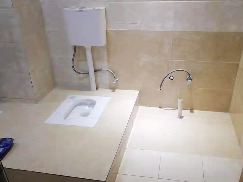 蹲便器安裝貼磚裝修：1.根據(jù)所安裝產(chǎn)品的排污口，在離墻適當(dāng)?shù)奈恢妙A(yù)留下水管道，同時(shí)確定下水管道入口距地平面的距離。 2.在地面下預(yù)留安裝蹲便器的凹坑深度大于便器的高度。 3.將連接膠塞放入蹲便器的進(jìn)水孔內(nèi)卡緊。在與蹲便器進(jìn)水孔接觸的外邊緣涂上一層玻璃膠或油灰，將進(jìn)水管插入膠塞進(jìn)水孔內(nèi)，使其與膠塞密封良好，以防漏水。 4.在蹲便器的出水口的邊緣涂上一層玻璃膠或油灰，放入下水管道的入口旋合，用焦渣或其它填充物將便器架設(shè)水平。 5.打開進(jìn)水系統(tǒng)，檢查各接合處有無漏水情況，若出現(xiàn)漏水，則要檢查各接合處的情況。直至問題解決。 6.檢查各接合處無漏水情況后，用填充物將便器周圍填實(shí)，同時(shí)陶瓷與水泥砂漿的接觸面填上 1cm 以上的瀝青或油氈等彈性材料。 7.用水泥砂漿將蹲便器固定在水平面內(nèi)，平穩(wěn)、牢固后，然后在水泥面上鋪貼衛(wèi)生間地磚。 8.試沖水，若無異常即可使用。