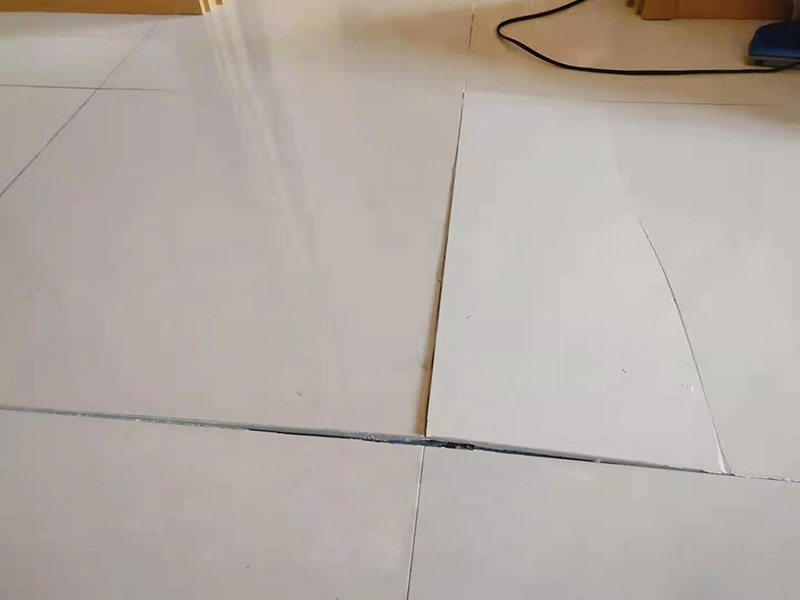 客廳地磚起翹修復(fù)：將油灰刀的邊緣滑入松散的瓷磚與其旁邊的瓷磚之間的接縫中。撬起瓷磚并將其移除。用金屬刮刀或小的撬桿的平坦邊緣刮掉基材和瓷磚背面的稀釋劑或瓷磚粘合劑。用相同的工具刮擦周圍空間的舊水泥漿。用清水沖洗除去翹起的瓷磚，然后用濕海綿擦拭，使其干凈。將砂漿抹在缺口邊緣上，然后將稀釋水泥砂漿抹在瓷磚的背面，將瓷磚鋪回原位。如果難以將瓷磚平整，則將瓷磚墊片插入接縫或修補物與包圍它的瓷磚之間的接縫或接縫中。刮掉多余的漿液，并讓該區(qū)域靜置約10分鐘。用水蘸軟海綿，然后輕輕擦拭修復(fù)區(qū)域。瓷磚上出現(xiàn)一層干粉后，請用干抹布擦拭。