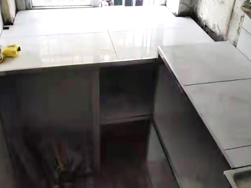 廚房磚砌櫥柜：櫥柜的水電定位時(shí)，先劃分功能區(qū)：洗菜盆區(qū)、灶臺區(qū)、切菜區(qū)、電器區(qū)，把這些區(qū)域的具體尺寸畫在墻面上，安排好進(jìn)水管、排水管和各種插座的準(zhǔn)確位置。 磚砌櫥柜制作的時(shí)候先做櫥柜的圍角，可以根據(jù)自己的喜好選擇不同顏色的瓷磚來實(shí)現(xiàn)。圍角完成以后的重要工作就是用水泥和砂漿將櫥柜的底部填實(shí)，上面鋪瓷磚。同時(shí)，瓷磚豎隔板的位置按照櫥柜圖紙進(jìn)行預(yù)留。 磚砌櫥柜制作好之后，我們可以根據(jù)自己喜歡的風(fēng)格選擇不同材質(zhì)的石材臺面和門板，完全不影響美觀，同時(shí)對于櫥柜內(nèi)部我們均采用不銹鋼條進(jìn)行收邊，既美觀又好打掃衛(wèi)生。