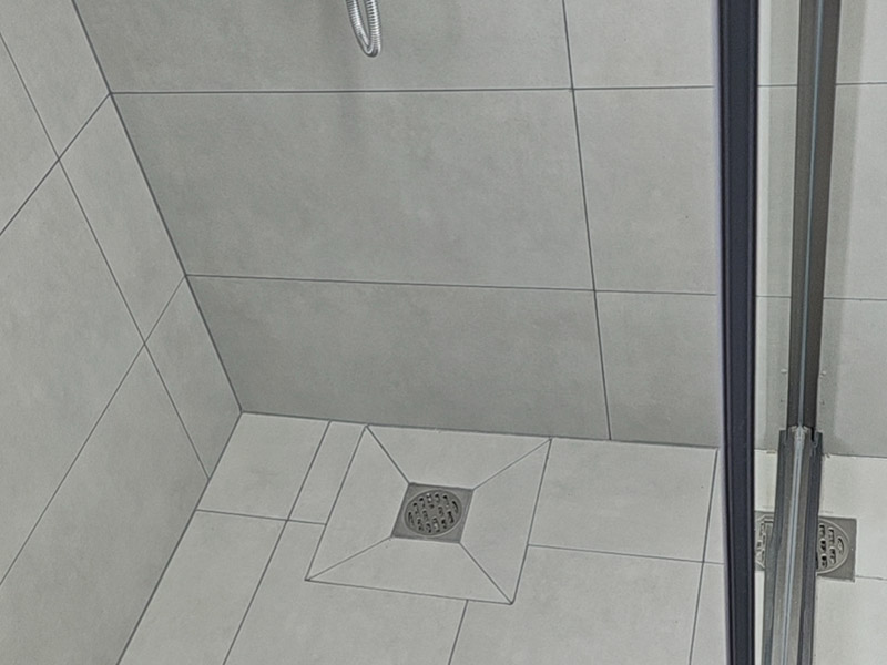 淋浴房地漏到底裝那個位置好